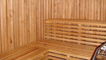 A sauna with wooden benches and a slatted ceiling.