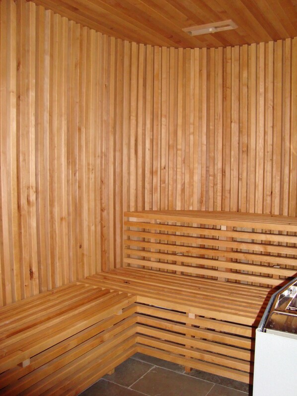 Una sauna con bancos de madera y techo de listones.