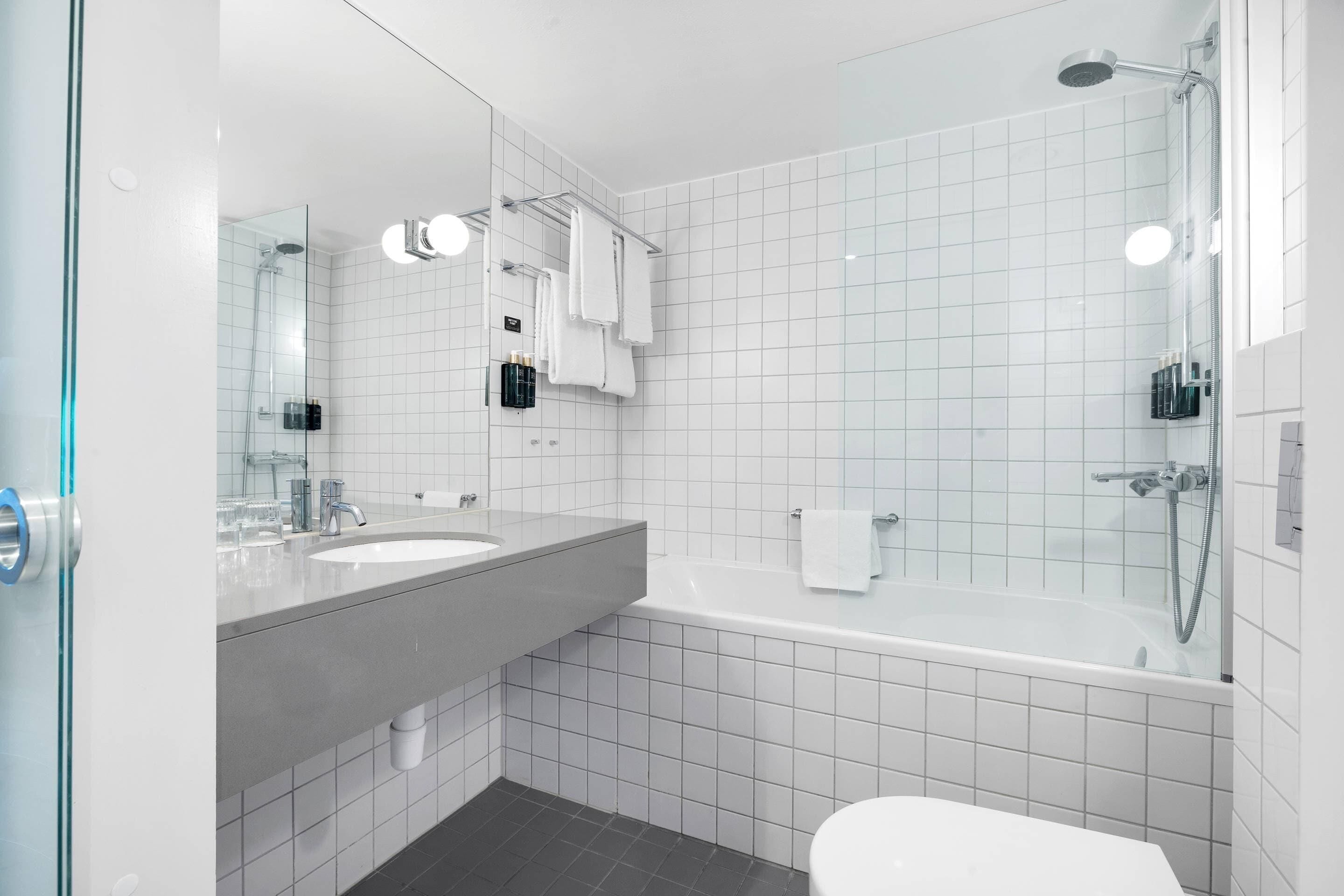 A modern bathroom with a large bathtub, a separate shower area, and a vanity with a sink.