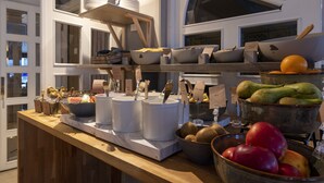 Disposição de buffet com diversos alimentos e utensílios.