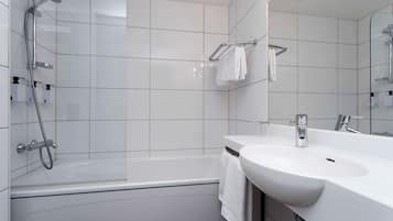 A modern bathroom with a bathtub, a sink, and a shower.