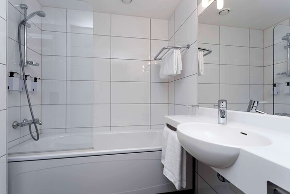 Un baño moderno con bañera, lavamanos y ducha.