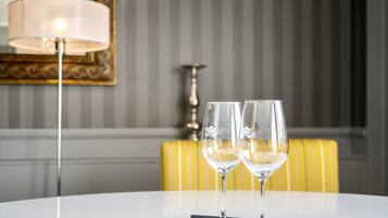 Two empty wine glasses on a white table with a lamp in the background.