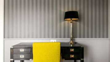 A room with a desk, a lamp, and a yellow towel.