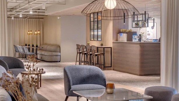 Un interior moderno con una zona de estar, bar y recepción.