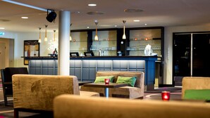 A modern hotel lobby with seating areas, a bar, and a reception desk. - Scandic Hammerfest (Hammerfest)