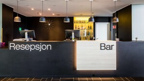 A reception area with a reception desk labeled "Resepsjon" and a bar area. - Scandic Hammerfest (Hammerfest)