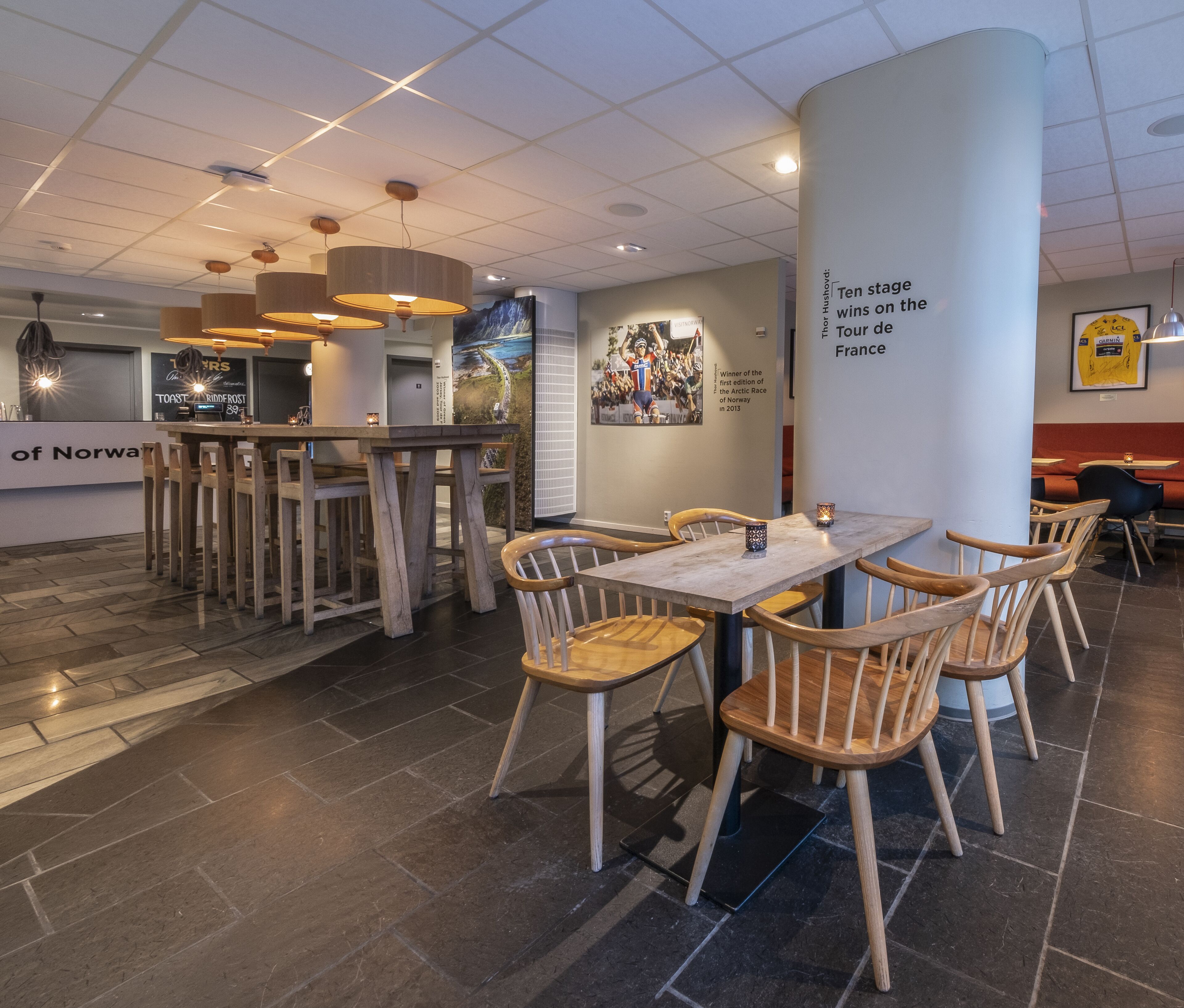A restaurant with a wooden table and chairs, a bar area, and a pillar with text.