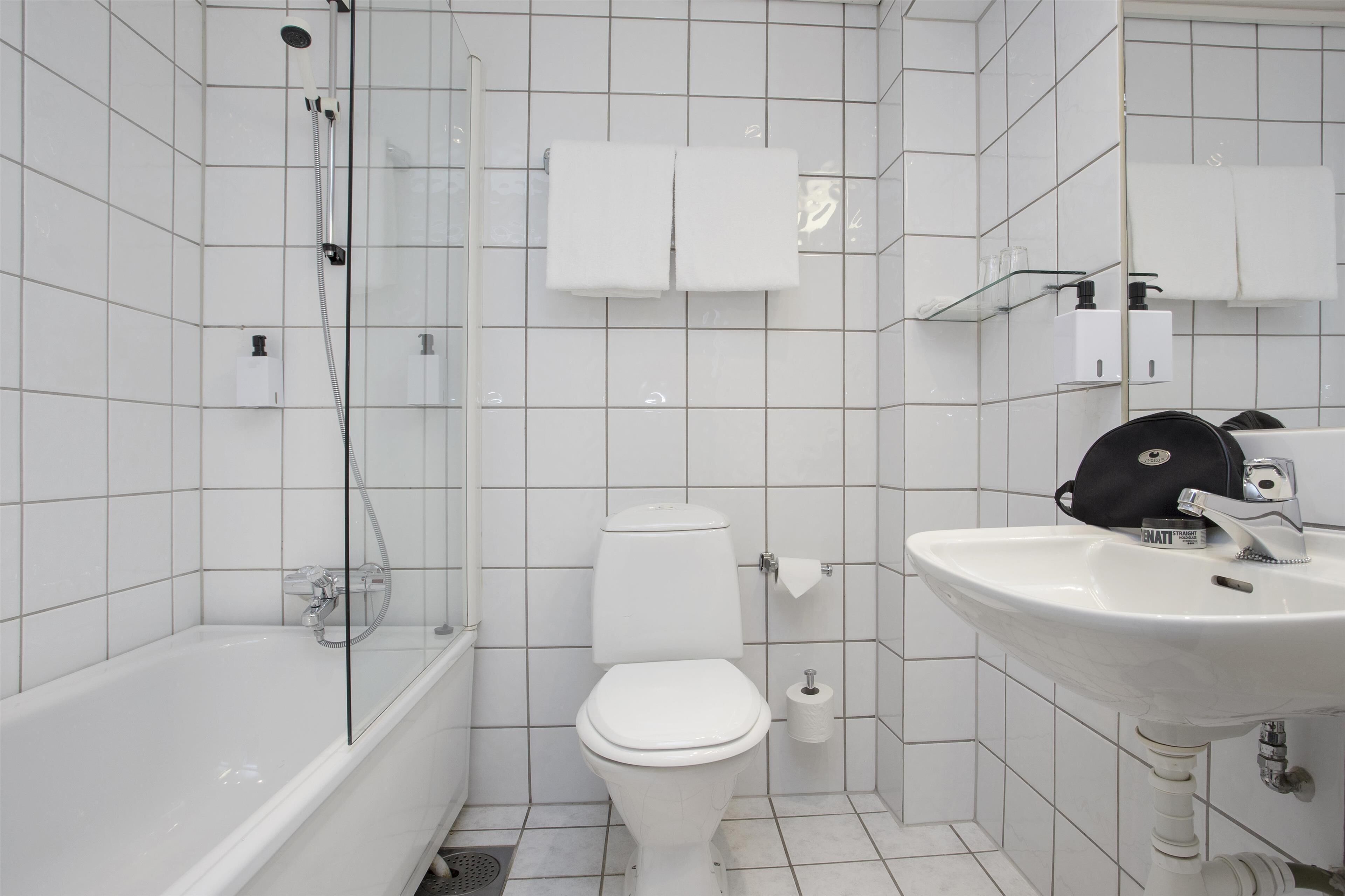 Un baño con bañera, inodoro y lavabo.