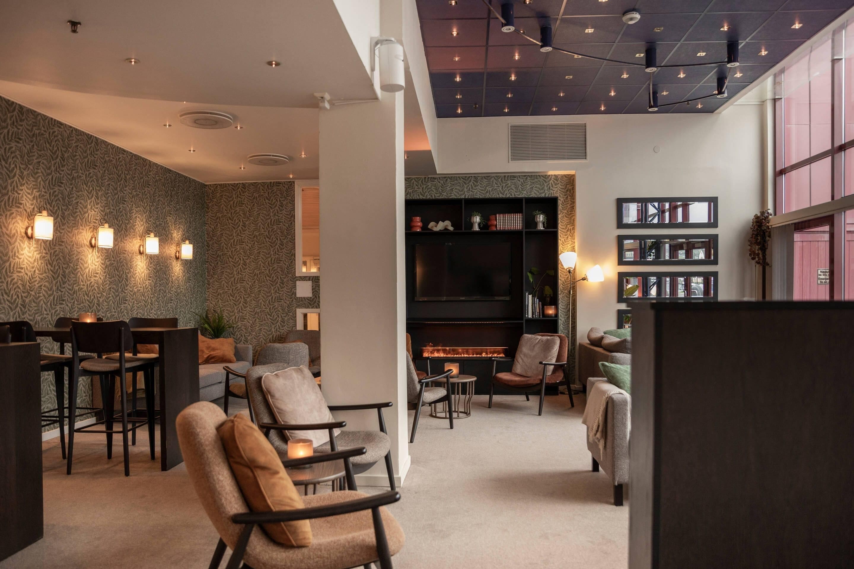 A modern interior with a fireplace, seating area, and a bookshelf.