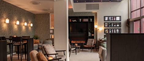 A modern interior with a fireplace, seating area, and a bookshelf.