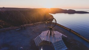 A coastal view with a metal chair and steps leading to a platform overlooking the sea. - Scandic Nordkapp (Nordkapp)