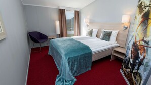 A hotel room with a bed, a desk, a chair, and a painting. - Scandic Nordkapp (Nordkapp)
