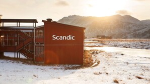 A building labeled "Scandic" with a staircase, located in a snowy landscape with mountains in the background. - Scandic Nordkapp (Nordkapp)