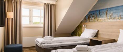 Una habitación de hotel con dos camas, una ventana con cortinas, una lámpara y un cuadro en la pared.