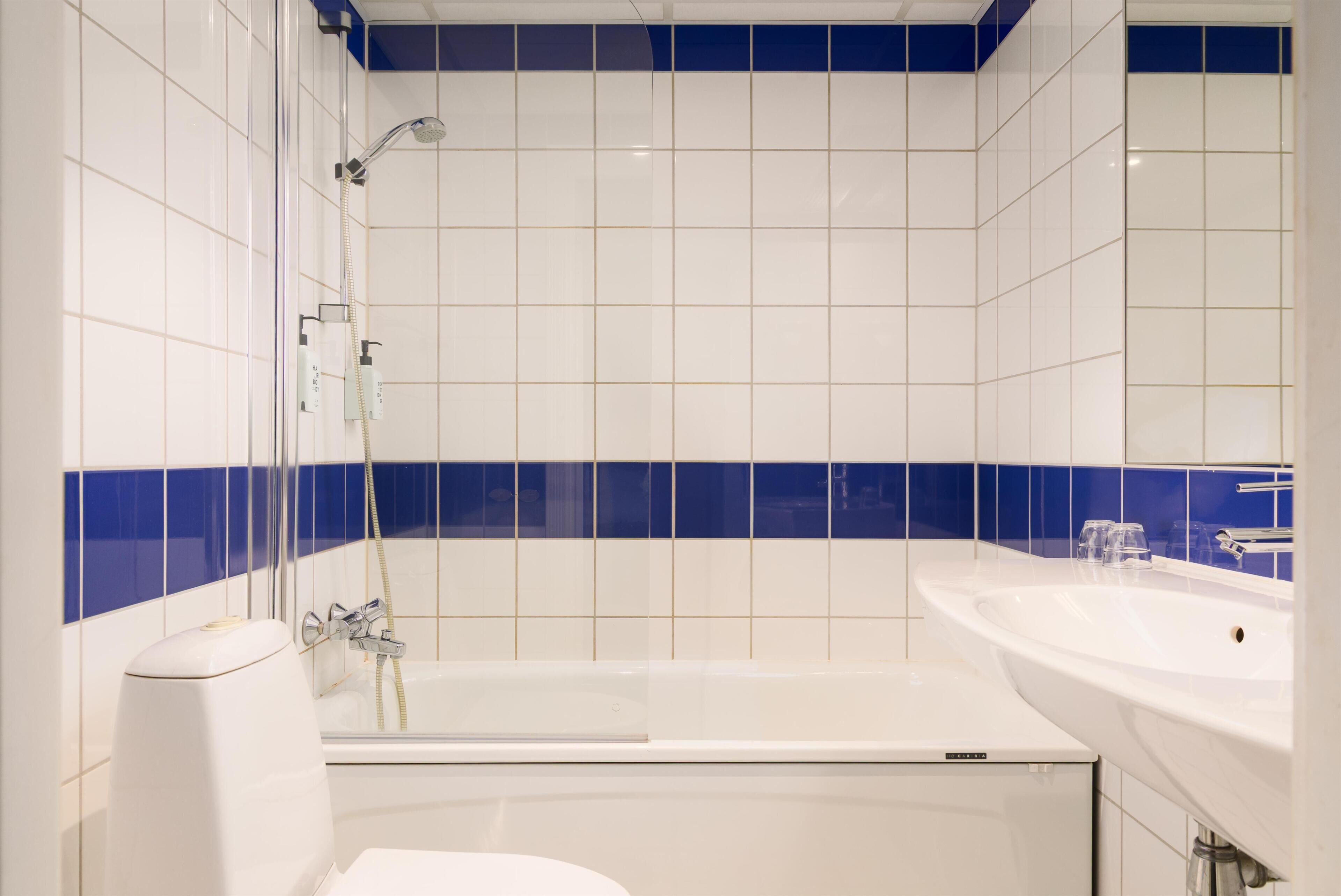 A modern bathroom with a bathtub, a shower, and a sink.