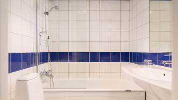 A modern bathroom with a bathtub, a shower, and a sink.