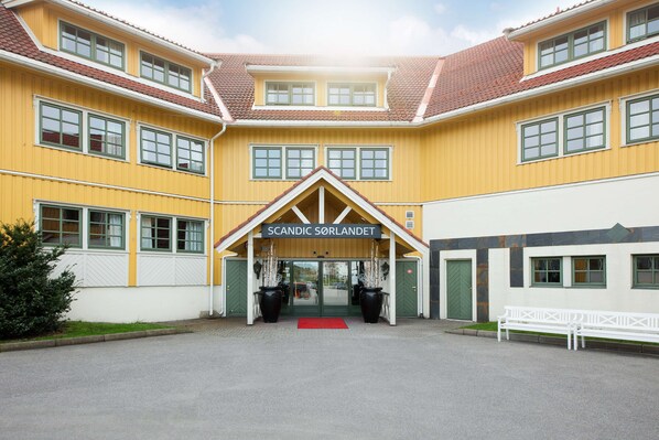 A yellow building with a sign reading "SCANDIC SÖRLANDET" at the entrance.