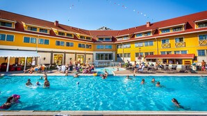 Un hotel con piscina rodeado de edificios amarillos con tejados rojos.