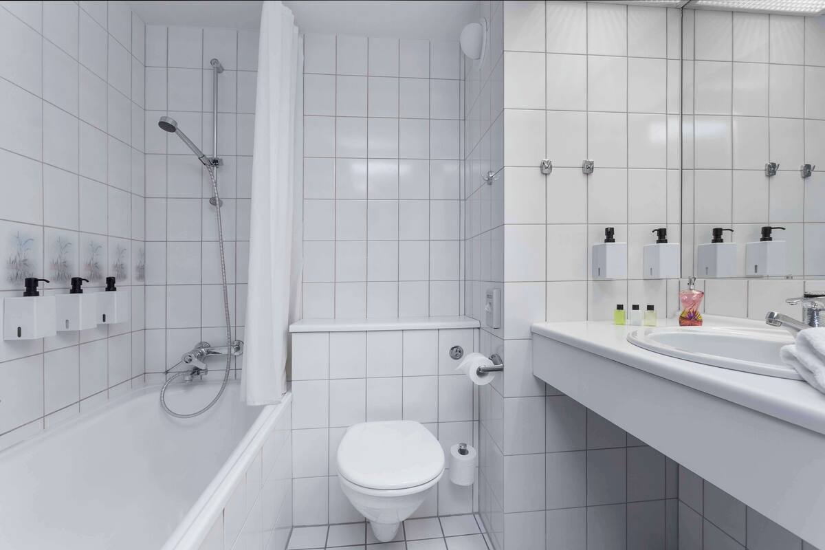 A modern bathroom with a bathtub, toilet, and sink.