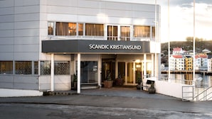 Um edifício moderno com uma placa que diz "SCANDIC KRISTIANSUND".