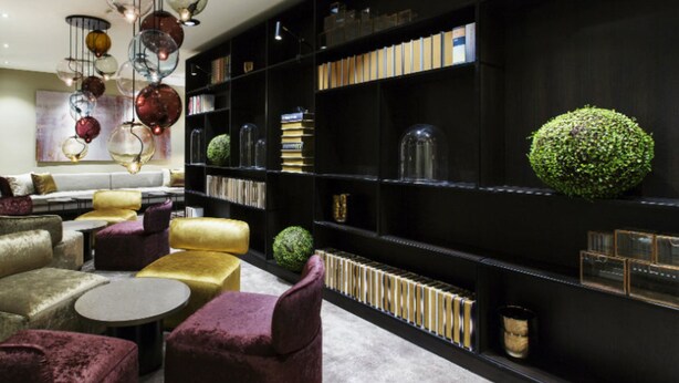 A modern interior with a black bookshelf, plush seating, and decorative globes. - Quality Hotel Grand Kristiansund (Kristiansund)