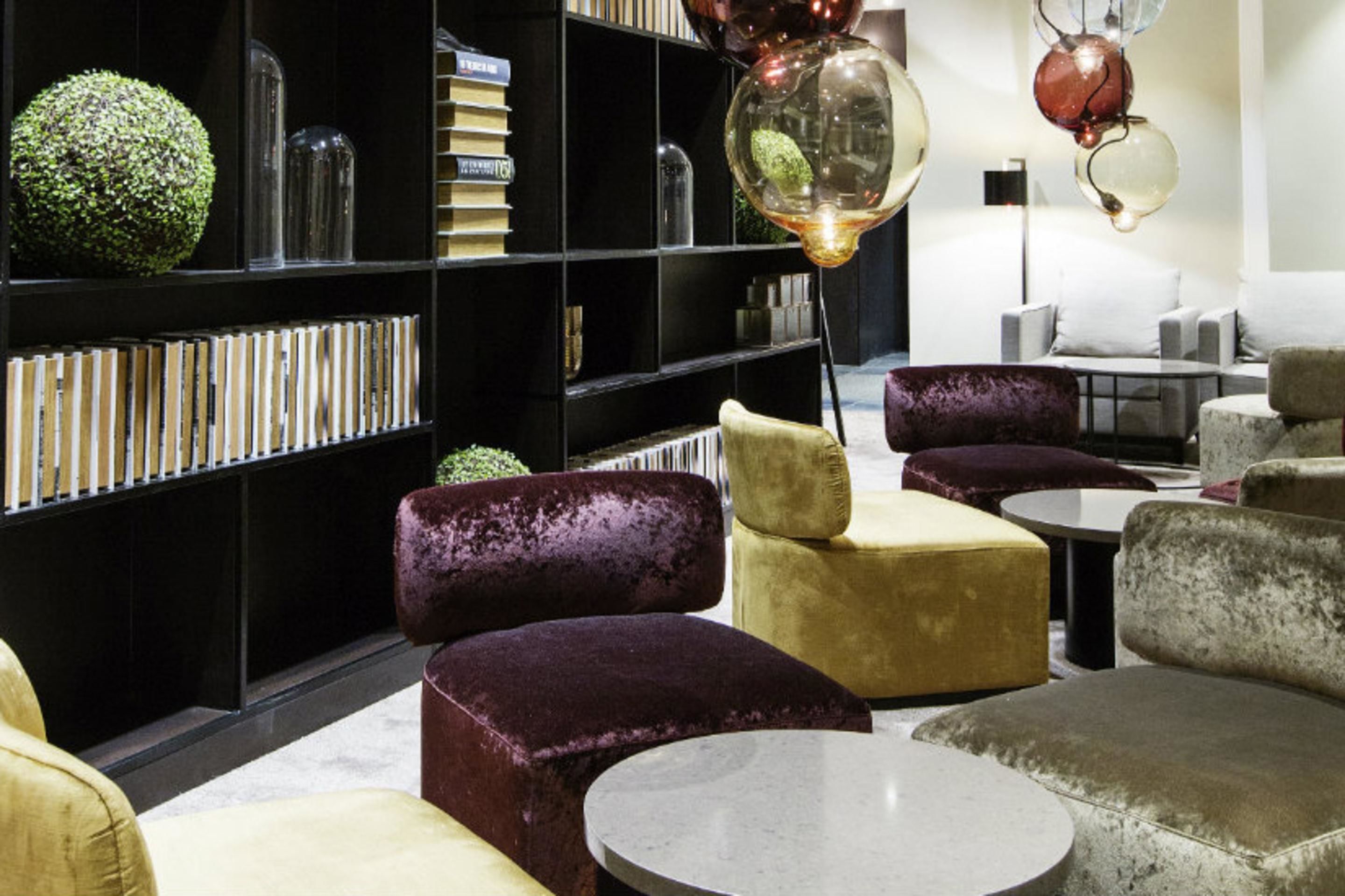 Un espace de détente moderne avec des fauteuils confortables, une bibliothèque et un éclairage décoratif.
