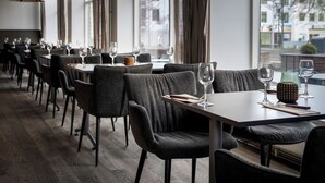 A restaurant with a long table, chairs, and hanging lamps. - Quality Hotel Grand Kristiansund (Kristiansund)