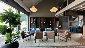 A modern living area with a sofa set, a large potted plant, and a built-in bookshelf.