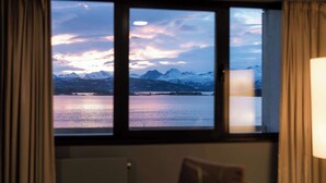 A room with a large window overlooking a mountainous landscape and a body of water. - Scandic Alexandra Molde (Molde)