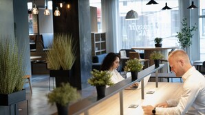 A modern reception area with a wooden reception desk, potted plants, and pendant lighting. - Comfort Hotel Børsparken (Oslo)