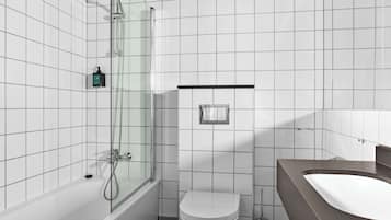 A modern bathroom with a glass-enclosed shower, a white toilet, and a large sink.