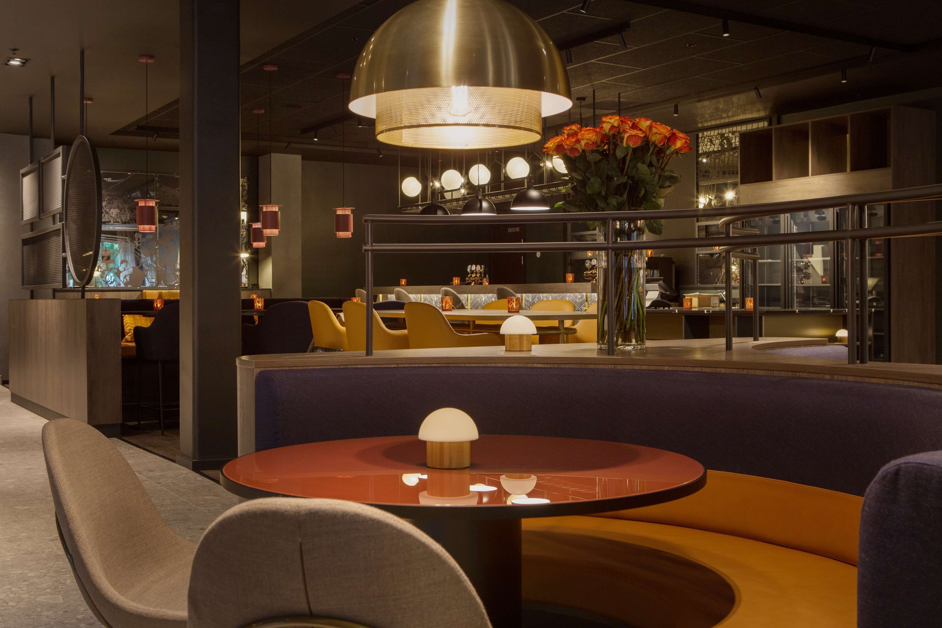 Un intérieur moderne avec des tables rondes, des sièges confortables et une pièce décorative centrale.