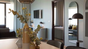 Un comedor con una mesa de madera, tres jarrones con flores y una decoración de estilo moderno.