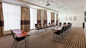 A conference room with a long table, chairs, and a projector.