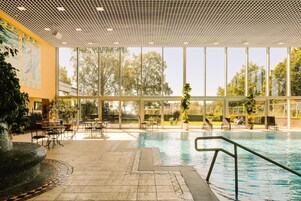 Una piscina techada, sillones reclinables de piscina