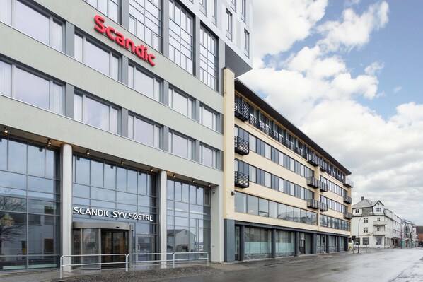 Situated on a street corner, this building features a prominent sign, large windows, and a glass entrance.