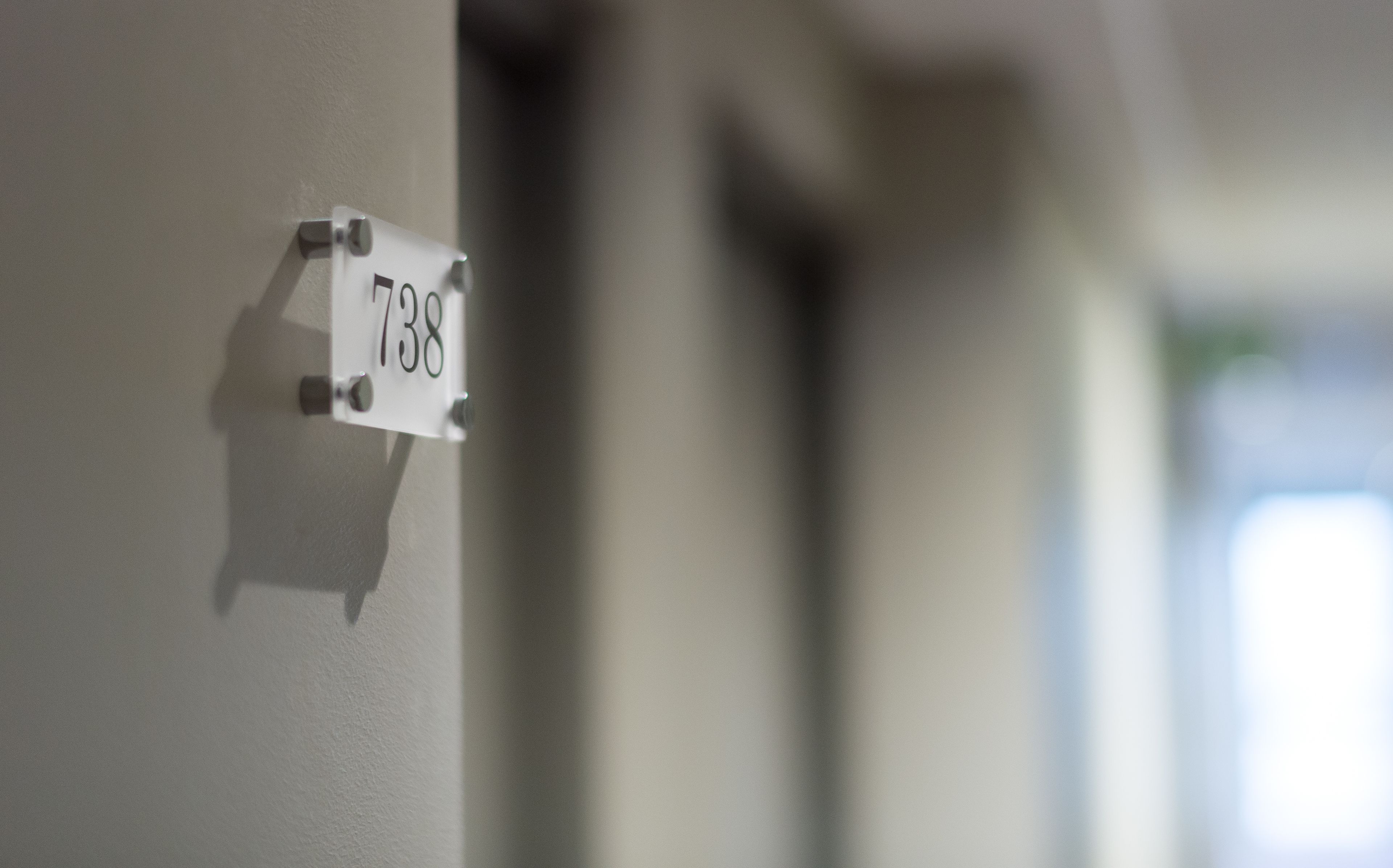 A white sign with the number 738 attached to a wall.