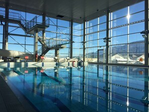 Swim laps in the pool with expansive views of the surrounding landscape, featuring a diving platform and stairs for easy access.
