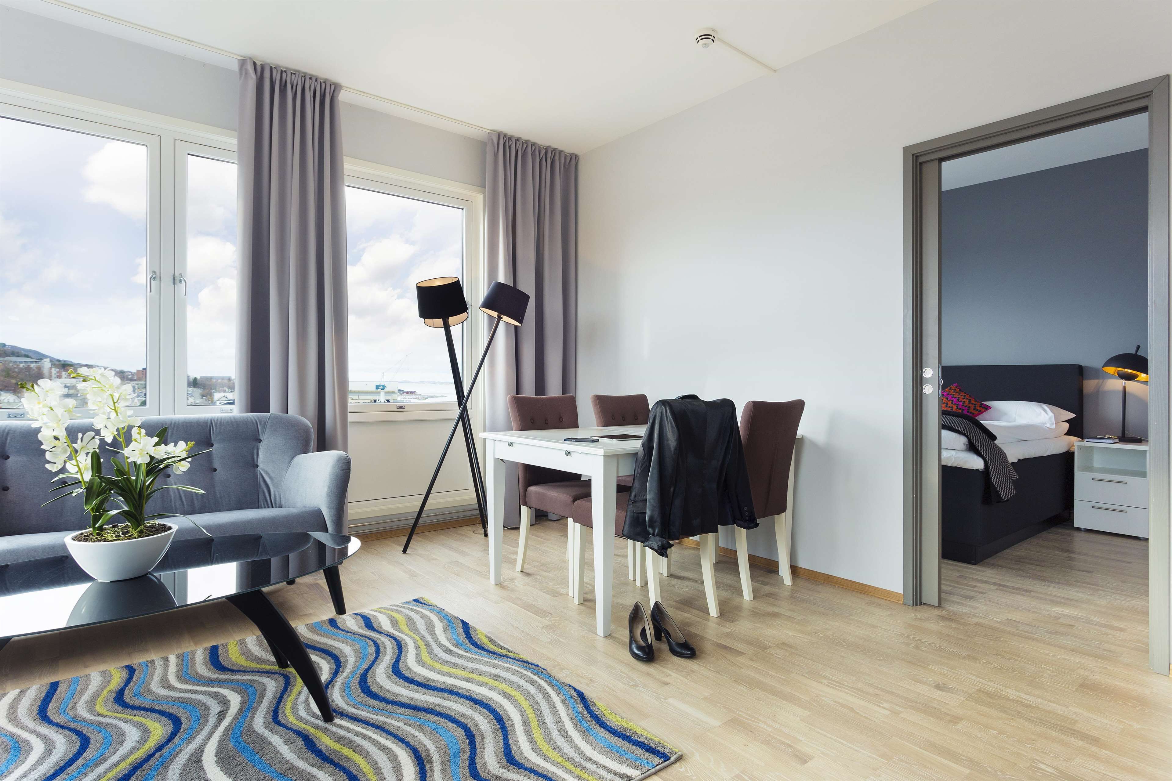 Ein modernes Hotelzimmer mit einer Couch, einem Esstisch und einem Bett.