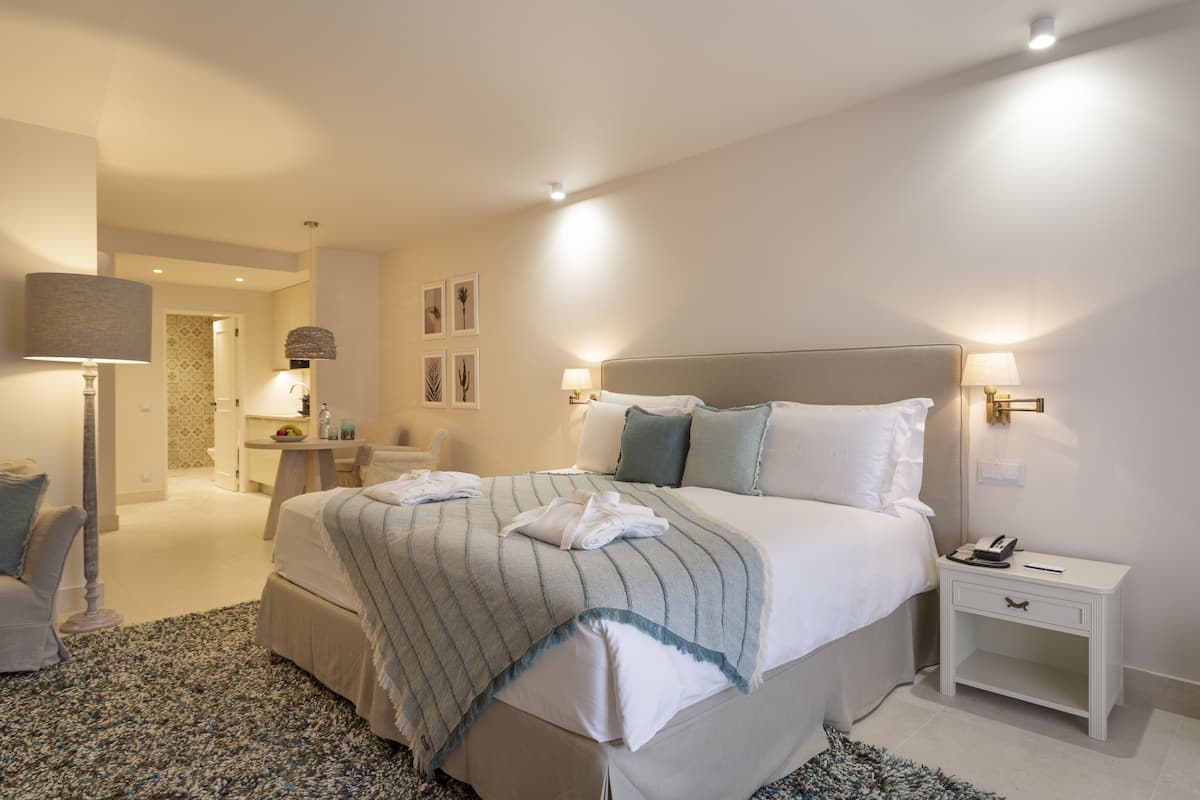 Een slaapkamer met een groot bed, nachtkastjes en een nachtkast.