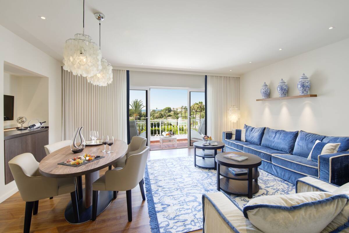 Een moderne woonkamer met een eethoek, een zithoek en uitzicht op het buiten.