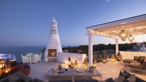 A rooftop terrace with a white conical structure, outdoor seating, and lanterns. - Vila Vita Parc  (Lagoa)