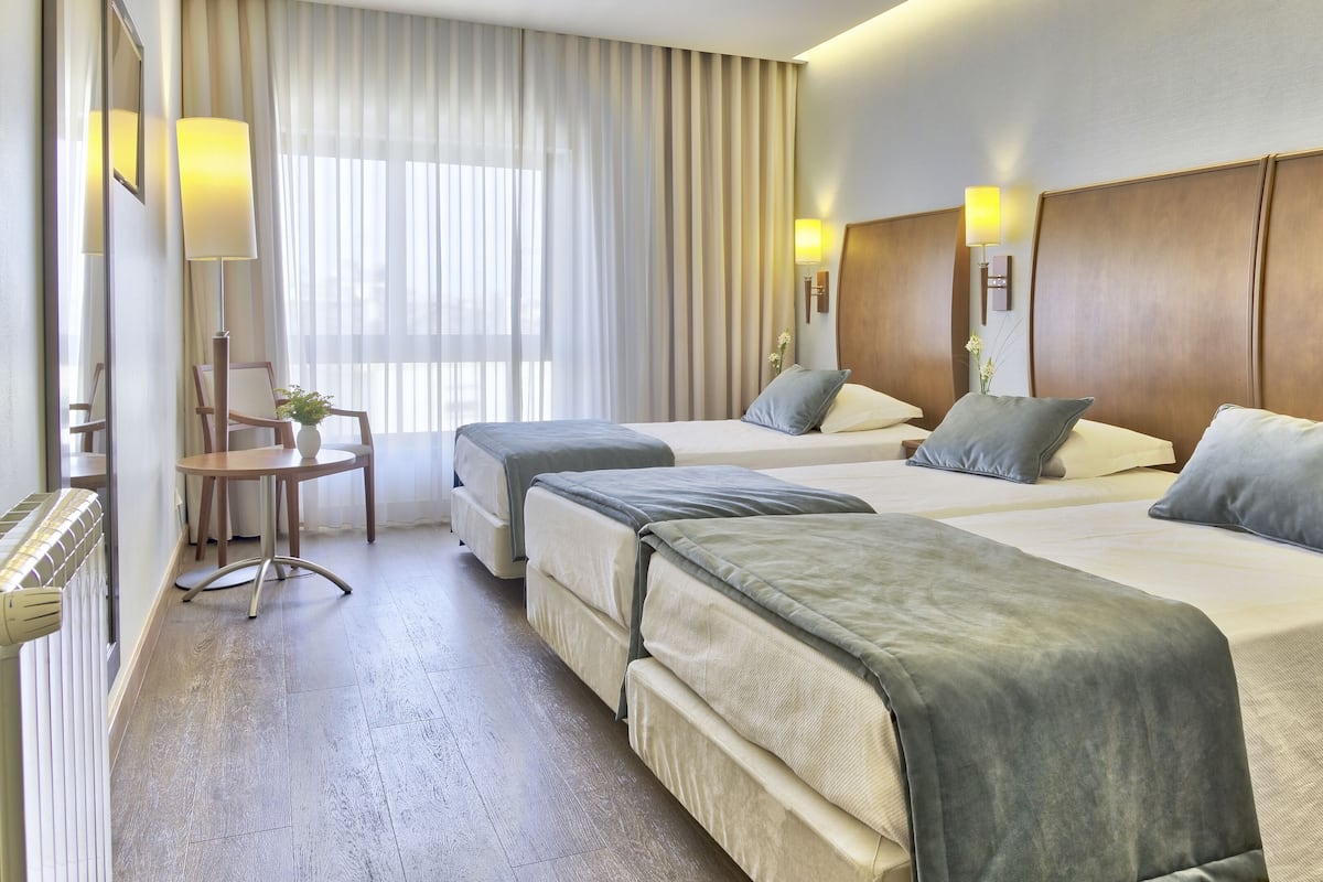 Habitación triple | Minibar, caja de seguridad en la habitación y muebles diferentes