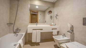 Un baño moderno con bañera, lavamanos y espejo.