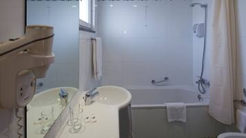 A bathroom with a sink, mirror, and shower.