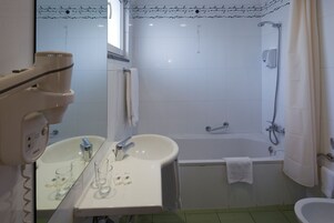 Un bagno con lavandino, specchio e doccia.