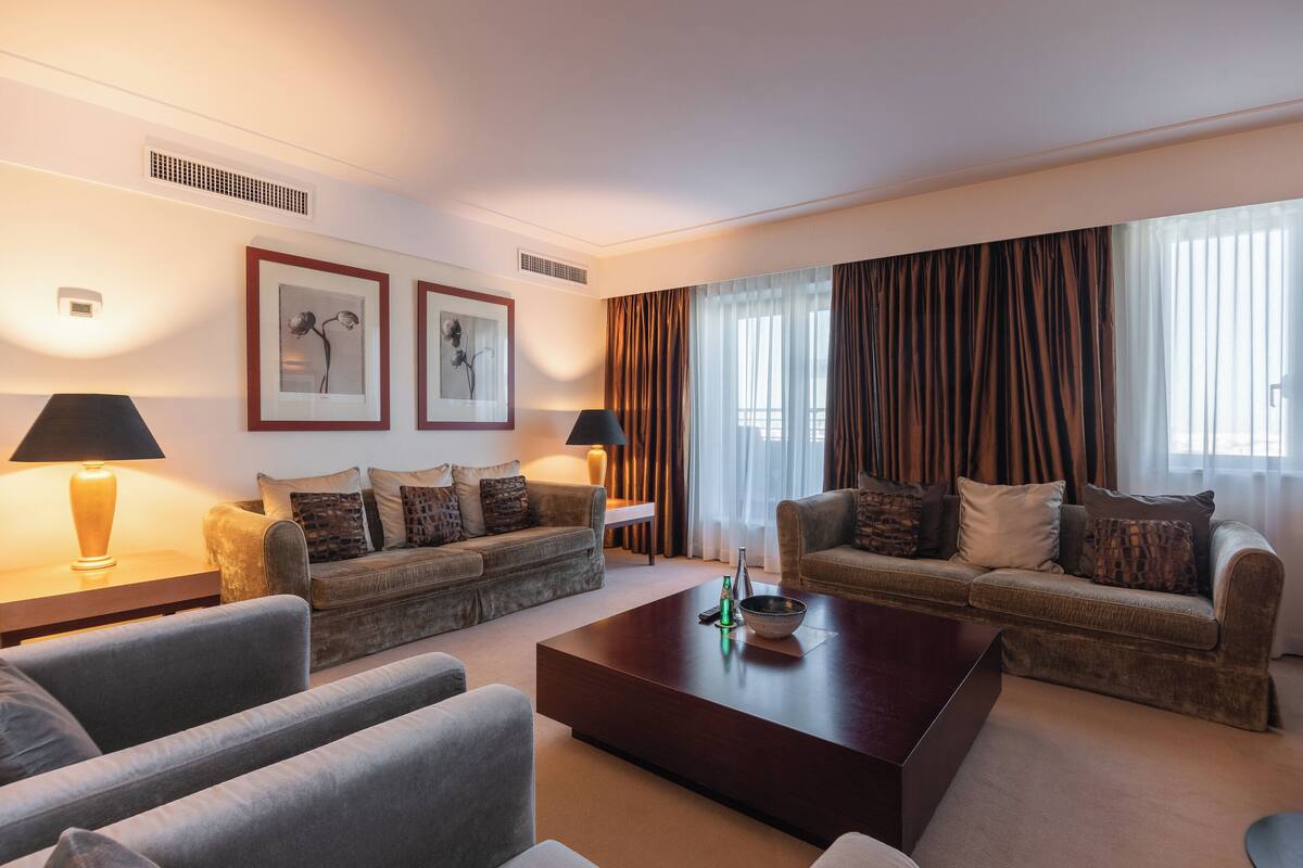 A modern living room with two sofas, a coffee table, and a lamp.