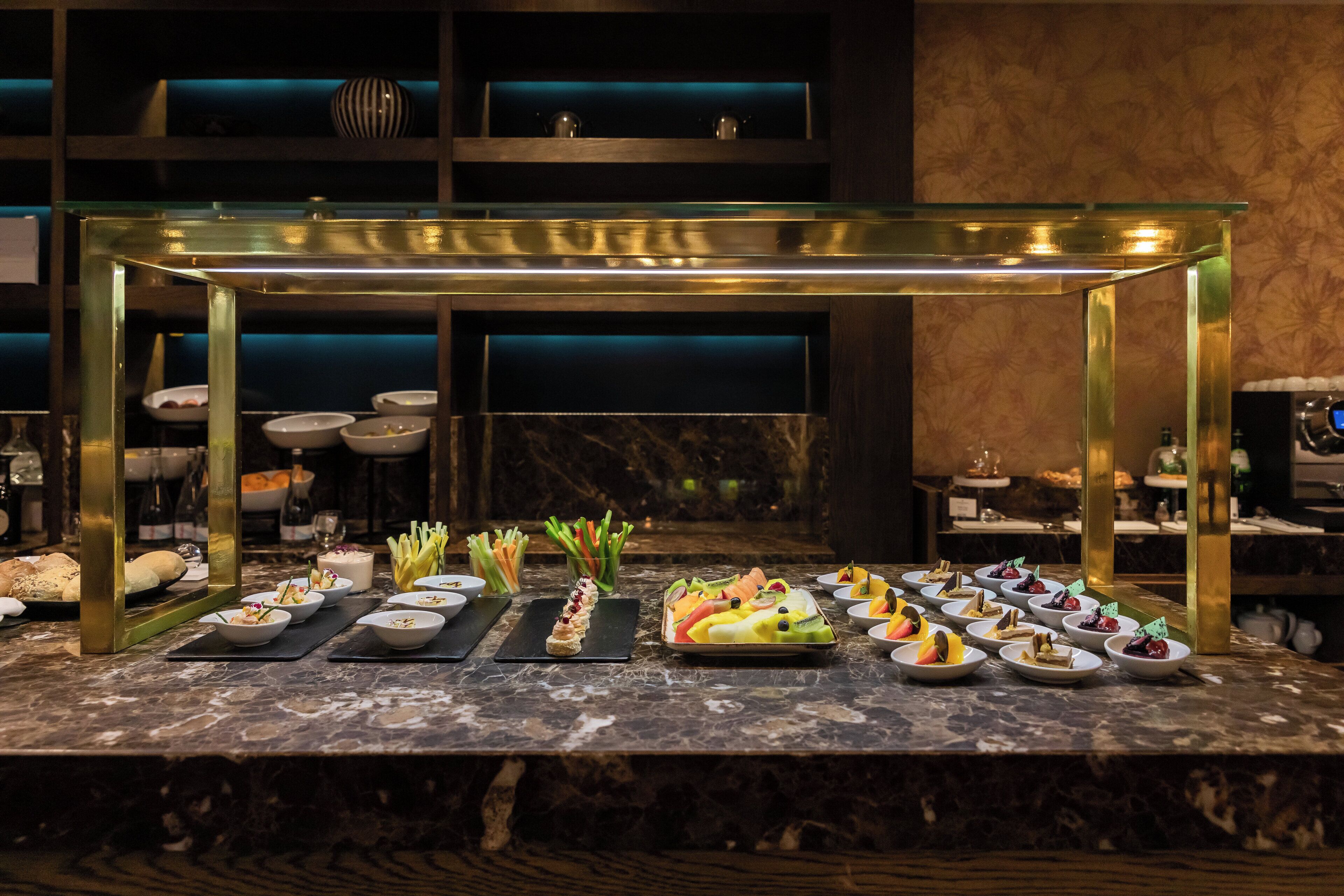 A marble-topped buffet table with various dishes and a glass-top serving station.