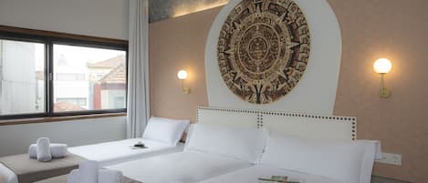 Ein Hotelzimmer mit zwei Betten, einem großen Wandbild und zwei Wandlampen.